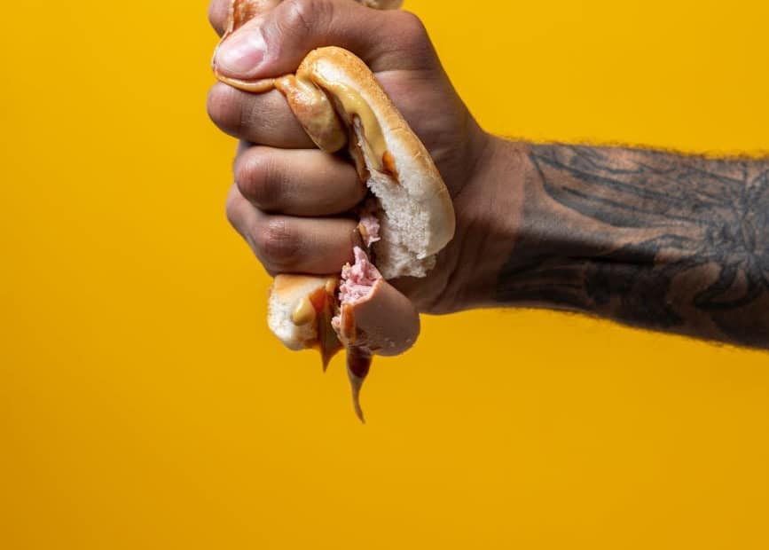 person squeezing hotdog